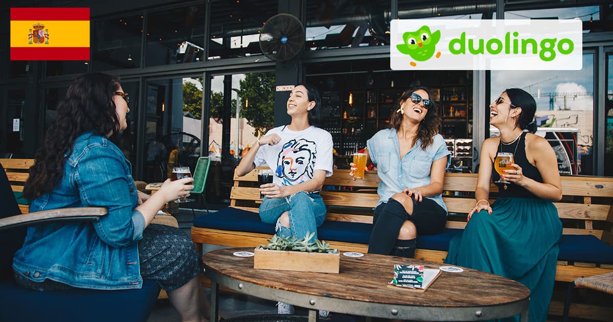 Discussion dans un bar en Espagne avec logo de Duolingo et drapeau Espagnol